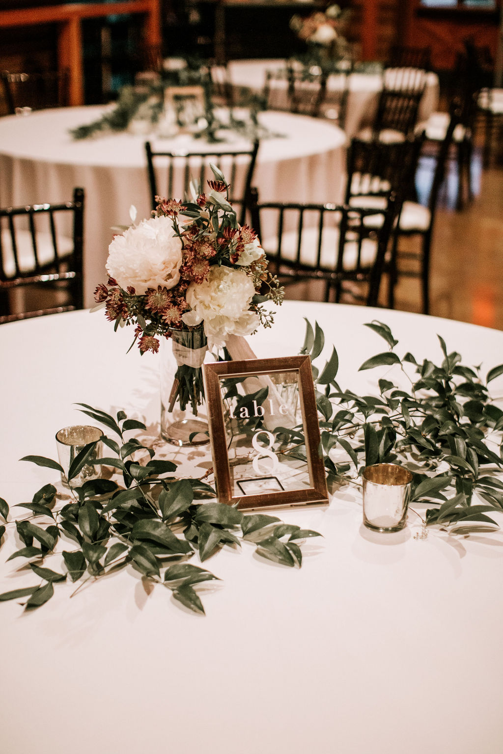 Elegant draping and dramatic lighting + florals for a surprise